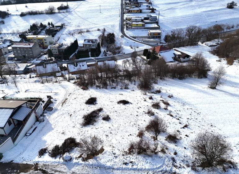 Snow-covered residential plots in Horná Mičiná with views of the surrounding houses and landscape.
