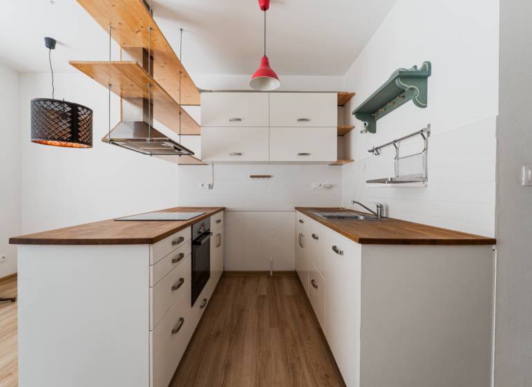 A kitchen corner in a 2-room apartment with wooden decor and pendant lights.
