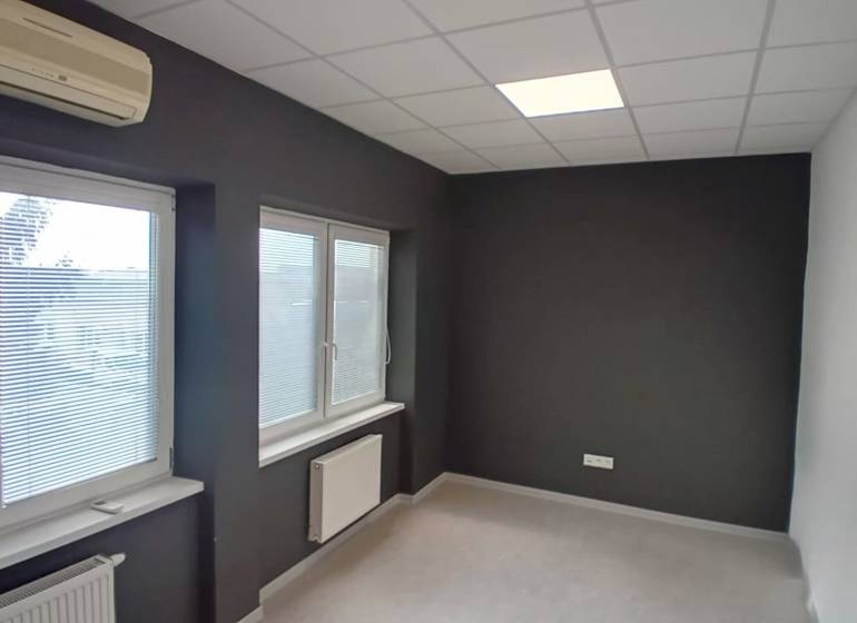 Offices with dark walls, windows with blinds, air conditioning, and radiators on the walls.