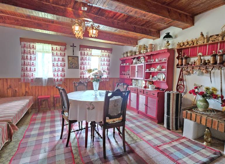 Traditional room in a family house with wooden ceilings, colorful furniture, and decorations.