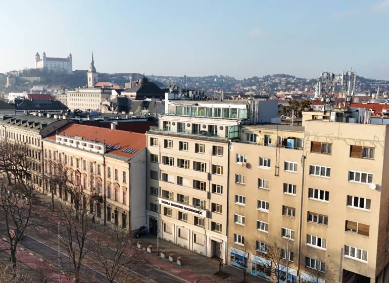 View of the Vajanského Embankment Building with Bratislava Castle in the background.