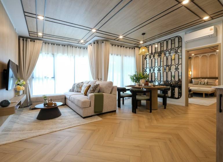 Living room in a 3-room apartment with a sofa, wall decor, and a wooden-patterned floor.