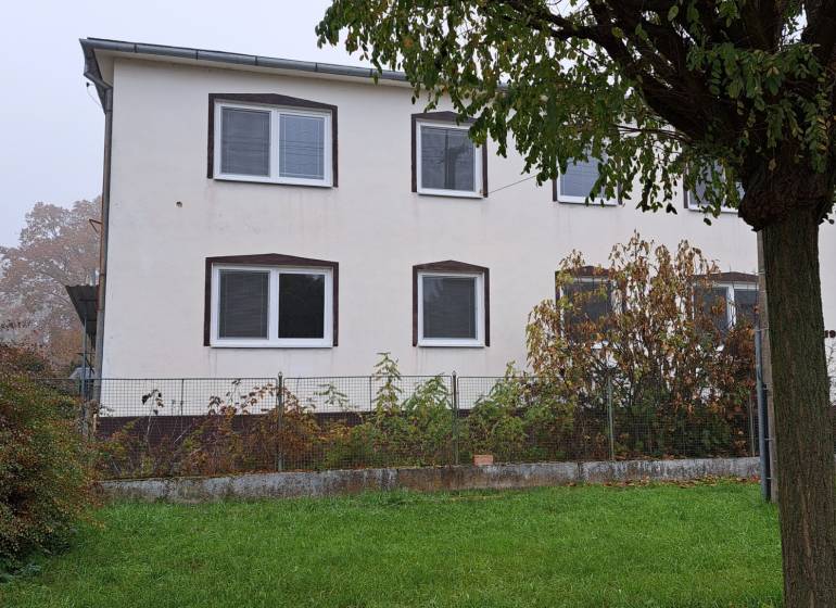 A family house in Kalná nad Hronom with a garden, a tree, and windows on the upper floor.