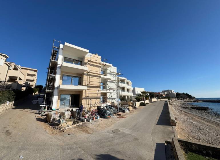 Seaside construction of 2-room apartments in Mandre by the sea, with scaffolding during construction.