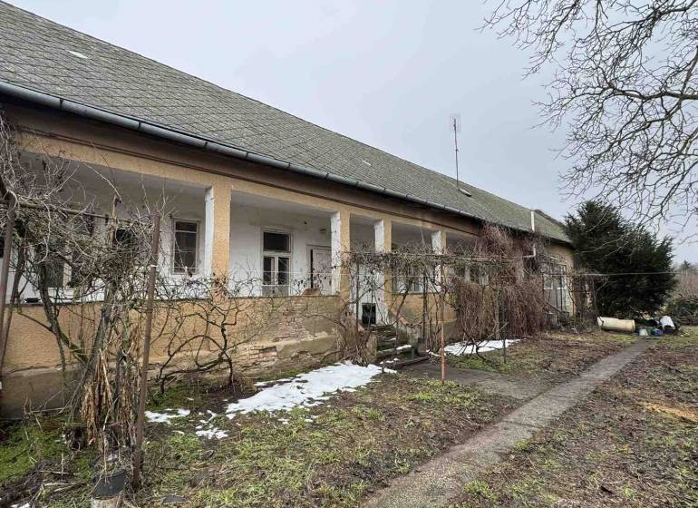 A family house on SNP in Šahy, in front of which there is a garden with bare branches and snow.