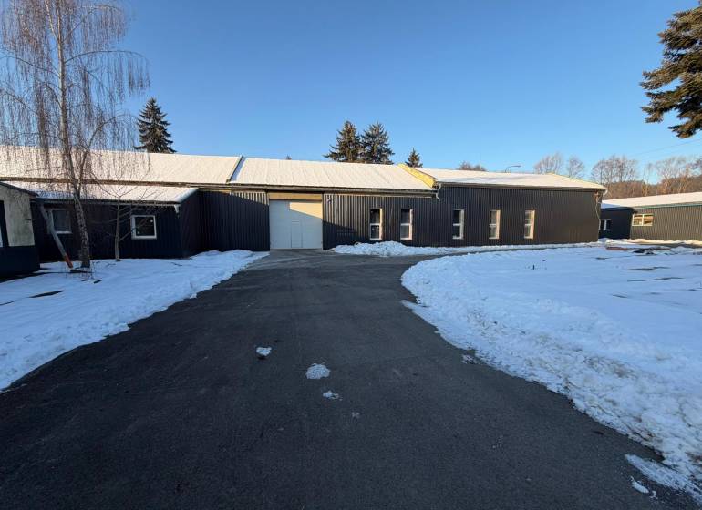 Halls on Pšurnovická Street in Bytča, covered with snow, with an asphalt road in front.