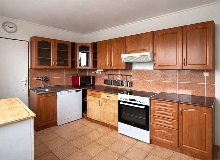 A kitchen with brown tiles and a countertop in a 4-room apartment.
