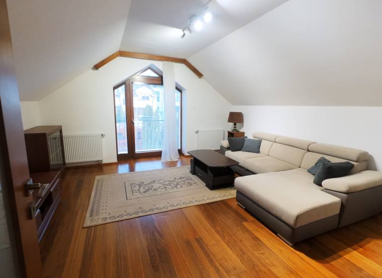A bright living room with a comfortable sofa and a wooden decor floor.