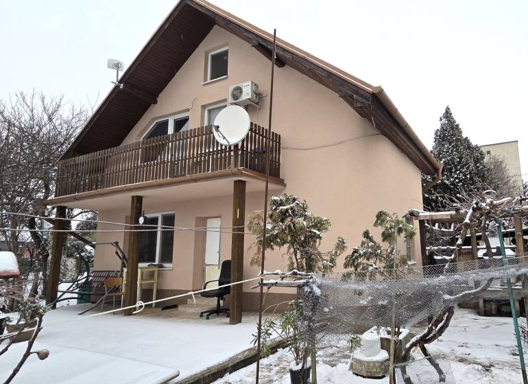 A family house in Trnava with a floor, a snow-covered garden, a terrace roof.