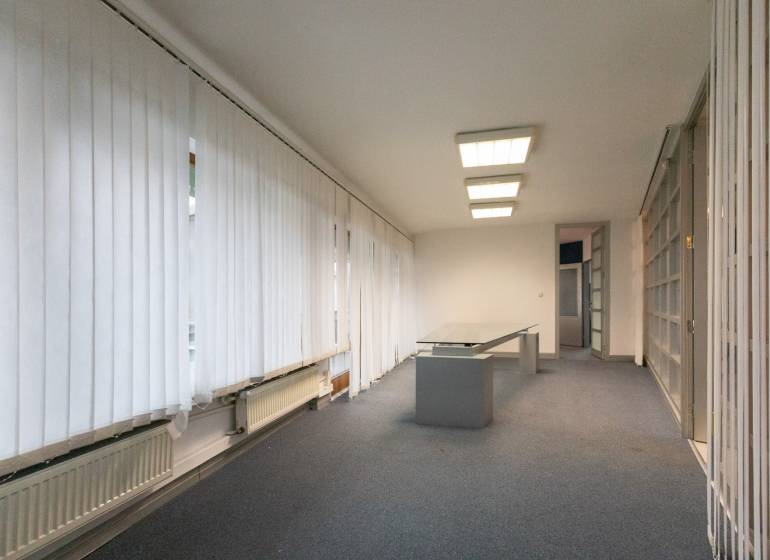 Interior with an office desk, light flooring, and vertical blinds in a 4-room apartment.
