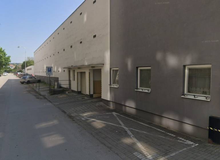 Garages on Laco Novomeský Street in Pezinok with a row of parked cars.