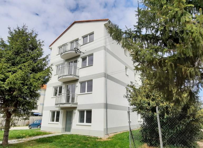 An apartment building on Školská Street in Chorvátsky Grob surrounded by greenery.
