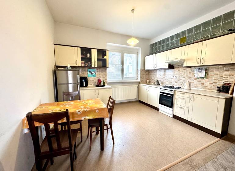 Kitchen in a 2-room apartment with a table, chairs, and a kitchen unit.