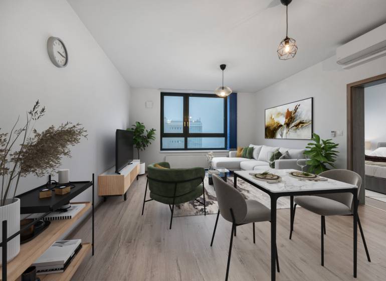 Living room with a sofa and a dining table in a two-room apartment, floor with wooden decor.