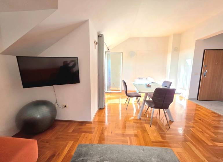 Interior of a holiday apartment with a wooden decor floor and a dining table.
