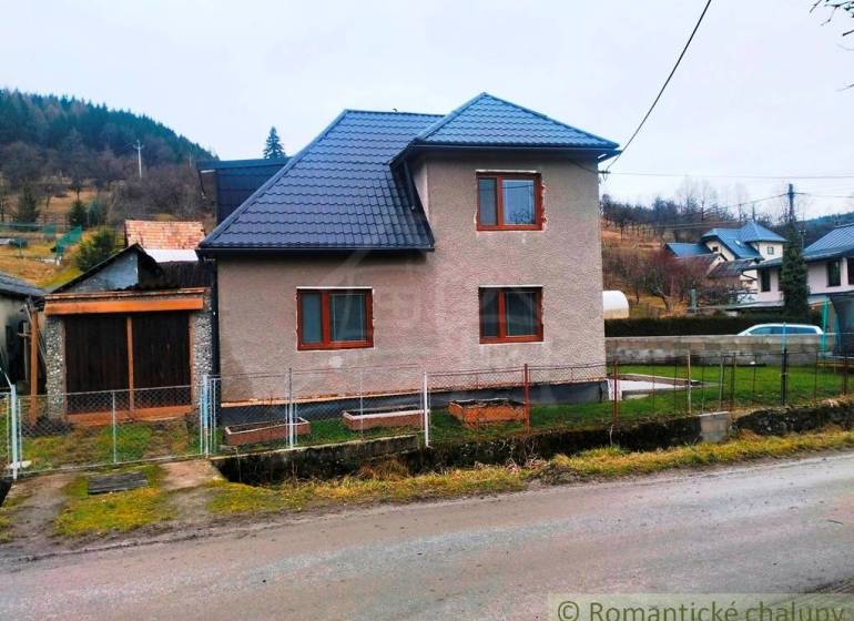 A family house in Jasenica with a new roof and a garden, surrounded by rural landscape.