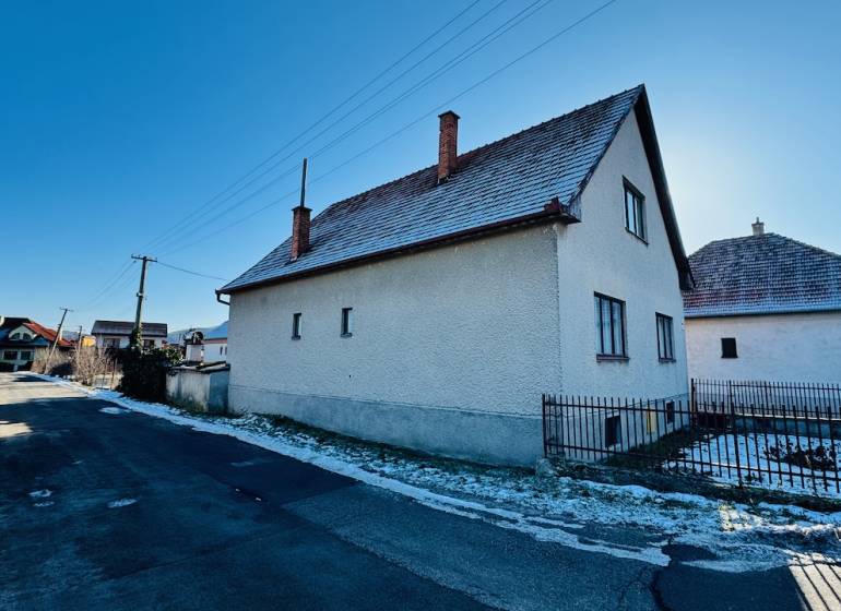 A family house on Veľké Bielice Street in Partizánske, next to the road, with a snow-covered garden.