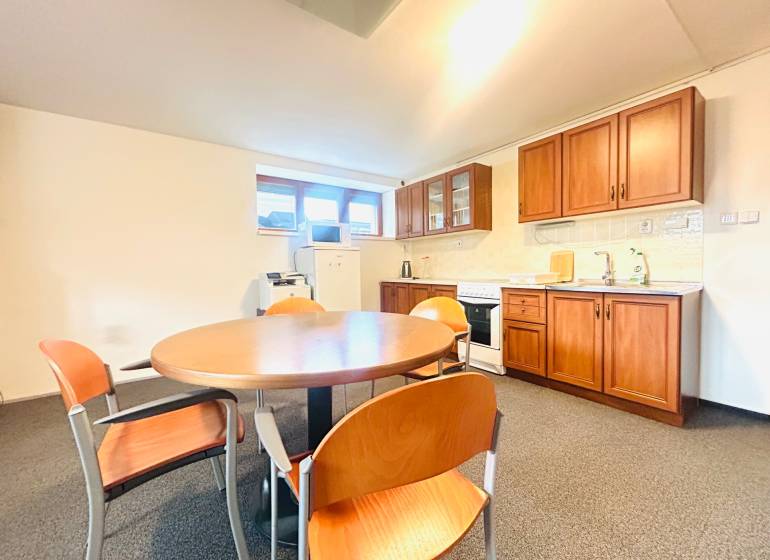 A kitchen in a family house with a dining table, chairs, and a kitchen unit with a wooden decor.