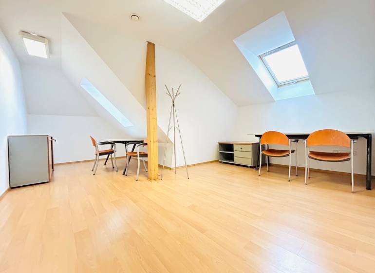 Offices with wood-patterned flooring, skylights, desks, and chairs.