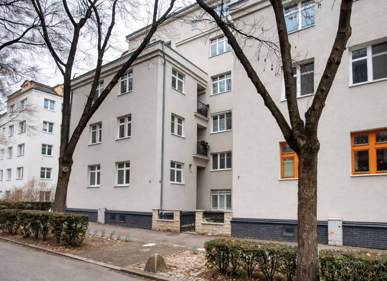 Apartment building in Bratislava at Jurajov Dvor, Pri starej prachárni. Four-story building, trees, sidewalk.