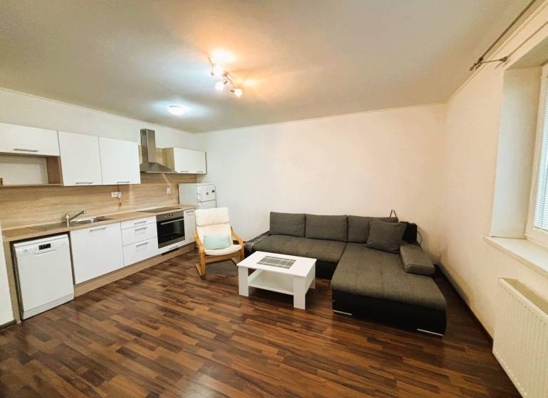 Living room in a two-room apartment with a corner sofa and a kitchen unit.