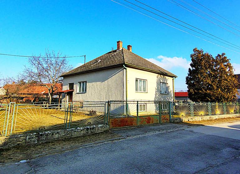A family house on Sadová Street in Borský Mikuláš with a fenced garden and blue sky.