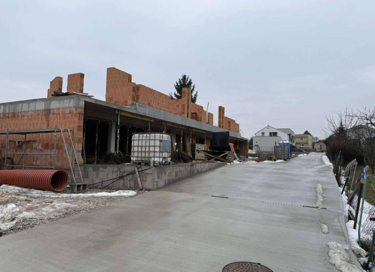 Construction of a family house in Višňové on Višňové Street during winter, with a view of the road.