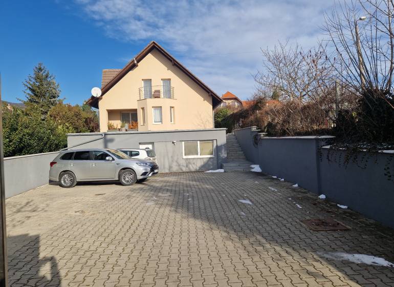 A parking lot with two cars in front of a family house on Jelenecká Street in Nitra.