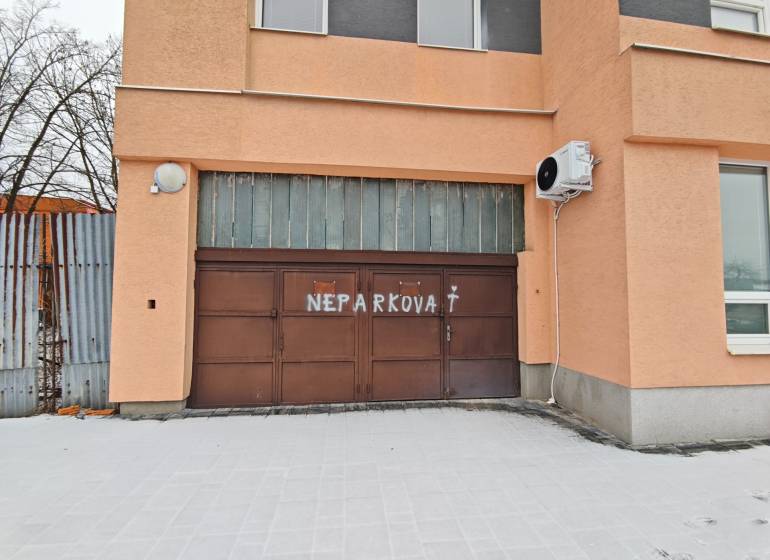 Garages on Hviezdoslavova Street in Michalovce with a no parking sign on the gate.