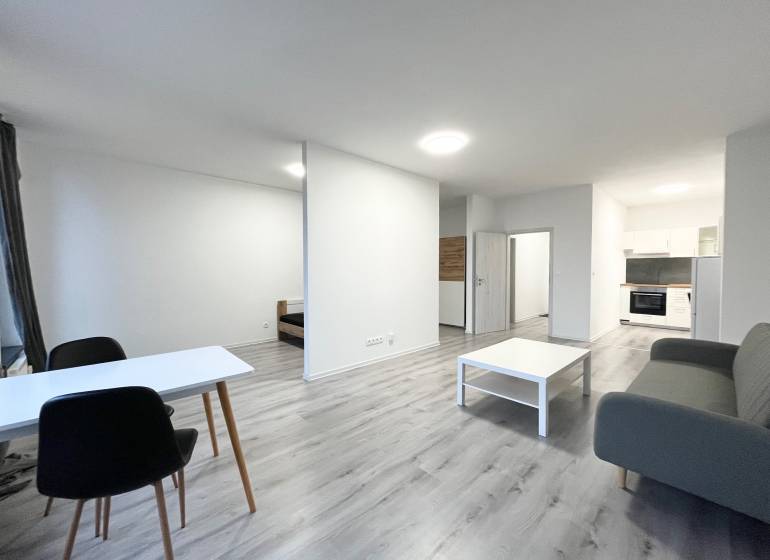 1-bedroom apartment with wood-patterned flooring, kitchen, and living room.