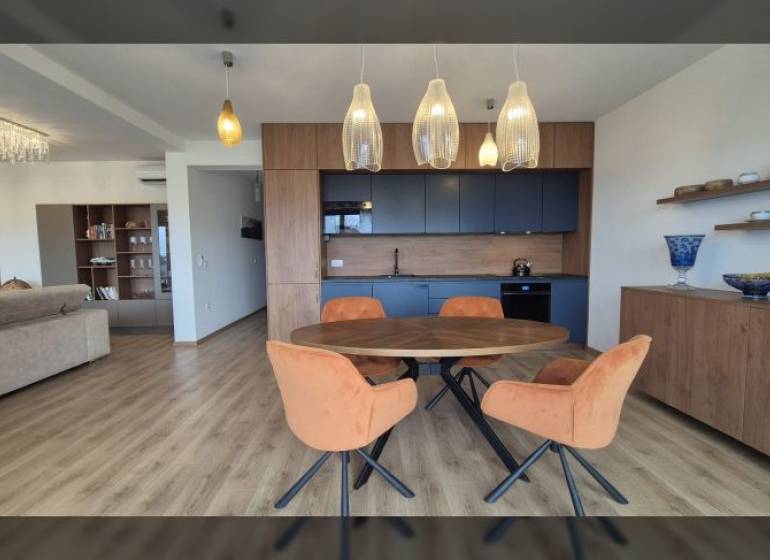Interior of a holiday apartment with a wooden decor floor and a dining table.