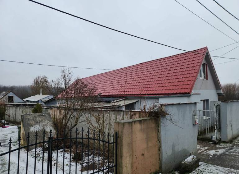 A family house in Tornyosnémeti with a red roof and a snow-covered yard.
