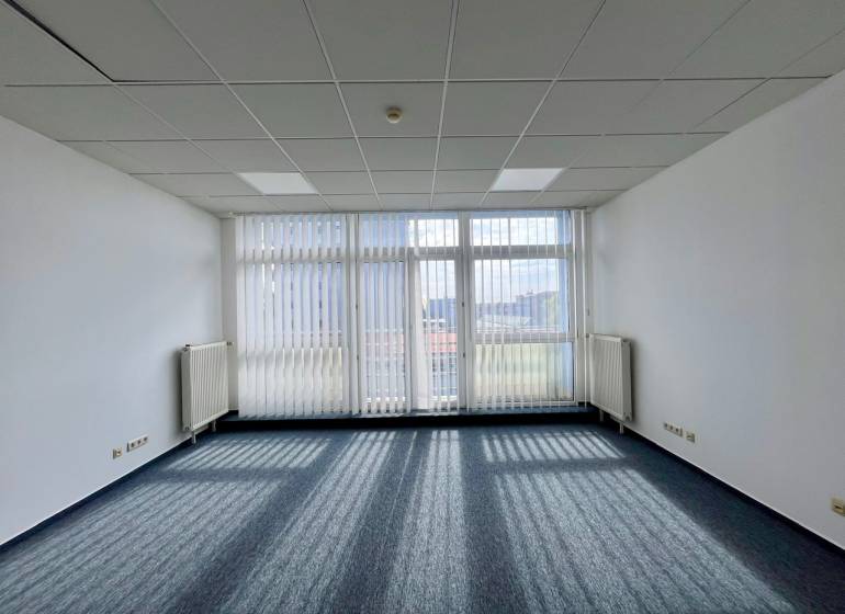 Offices with carpeted floors and large windows, providing a bright workspace.
