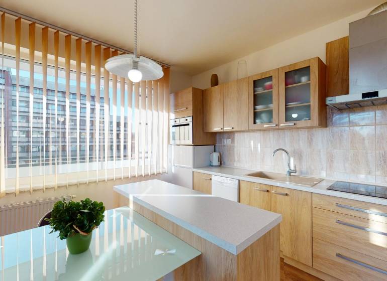 A kitchen with a wooden decor floor in a 2-room apartment, light furnishings, and a large window.