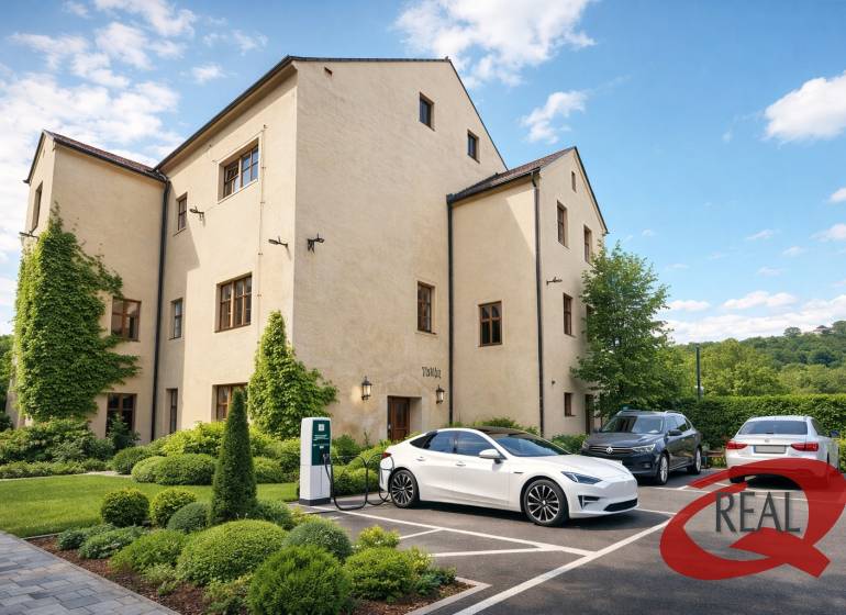 A building in Veľké Uherce with greenery and a charging station for electric cars in the parking lot.