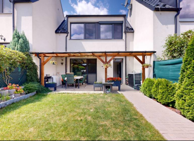Garden and terrace at a family house in Stupava with a manicured lawn and flowerbed.