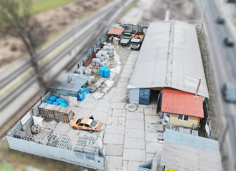 Production premises in Konská with cars and construction material near the railway track.