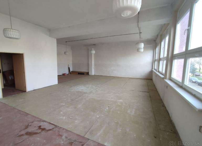 Spacious offices with large windows and wood-patterned flooring.