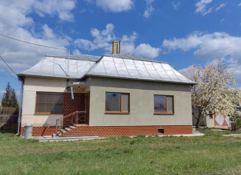 A family house in Veľké Raškovce with a steel roof and basic facade, front garden.