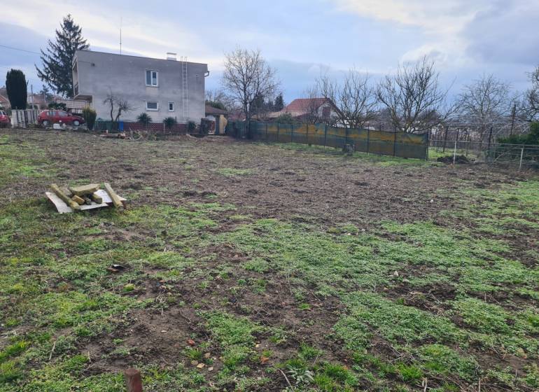 A plot for residential use in Svätý Peter with an older house and a landscaped garden.