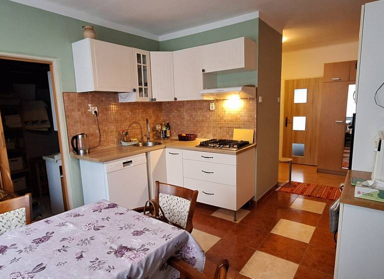 Kitchen in a 3-room apartment with a kitchen unit, hob, and coffee maker.
