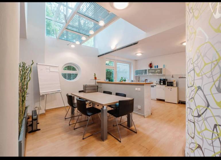 Interior of a family house with a dining table, round window, and floor with wood decor.