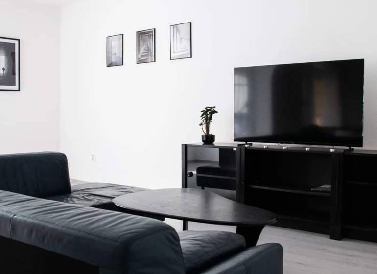Living room with a corner sofa and a television in a 2-room apartment.