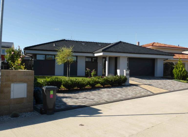 A family house in Banská Bystrica with a garden and a paved driveway.
