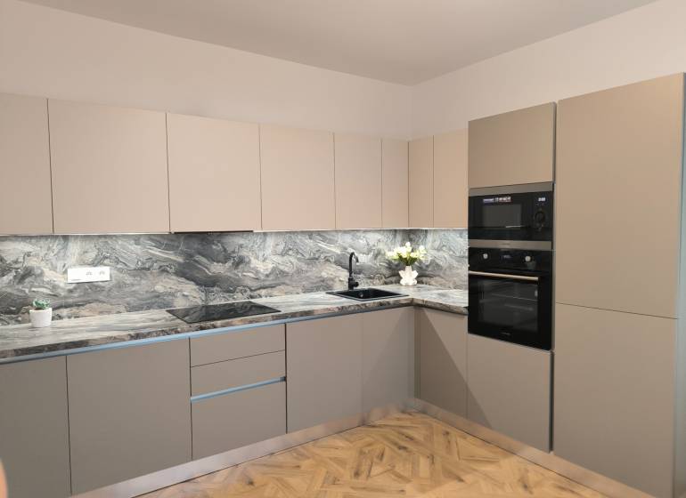 A kitchen in a 4-room apartment with marble tiles and a wooden decor floor.