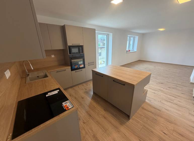 A kitchen in a family house with a wooden decor floor, bright and spacious layout.