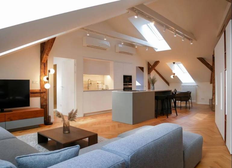 Attic interior with a kitchen, sofa set, and wooden decor flooring, 3-room apartment.