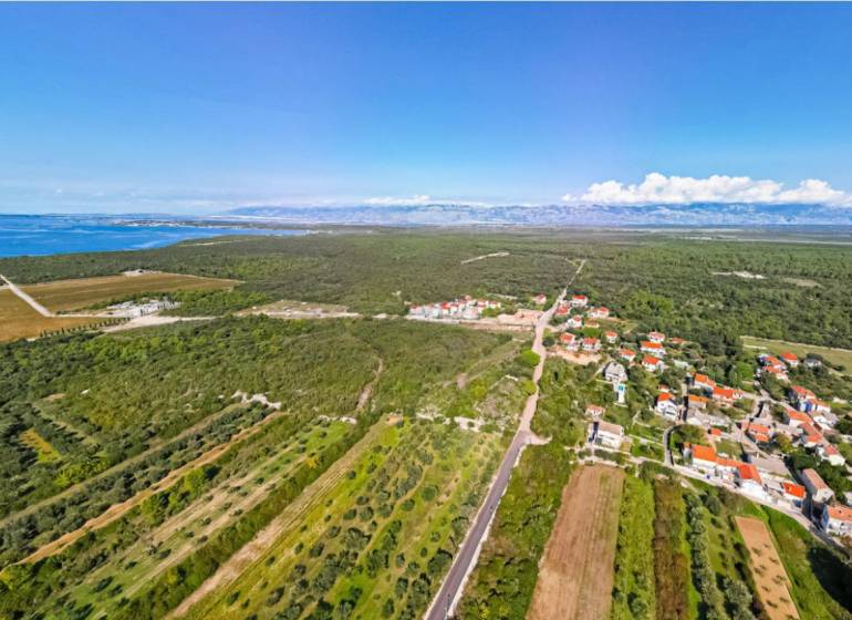 Aerial view of the landscape in PETRČANE with rural houses and fields near 2-bedroom apartments.