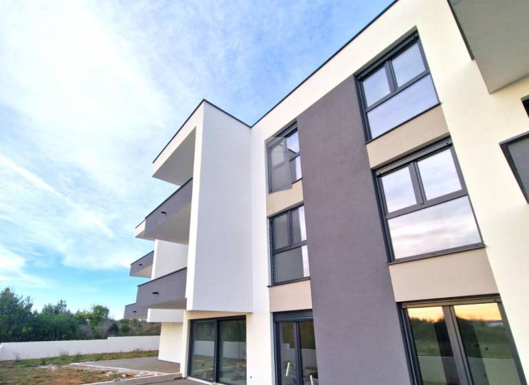 A new building with balconies in the town of Privlaka offers three-room apartments and a garden.