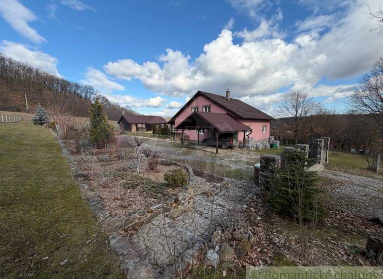 A family house in Lukovištia surrounded by nature, trees, a path, blue sky, clouds.